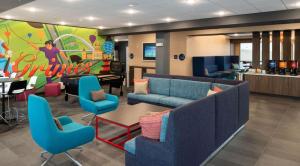 a waiting room with couches and chairs and a table at Tru By Hilton Grimes Des Moines in Grimes
