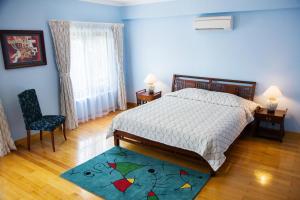 - une chambre avec un lit, une chaise et un tapis dans l'établissement Mayfair Hanoi, à Hanoï