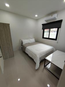 Postel nebo postele na pokoji v ubytování The White House Chalong