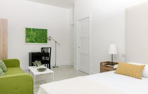 a living room with a white bed and a green couch at Fuorlovado 40 in Capri +11 photos