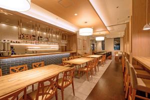 a restaurant with wooden tables and chairs and a bar at Hotel Mystays Premier Akasaka in Tokyo