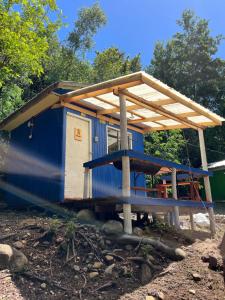 a blue house with a roof on top of it at Ancoa Lodge in Linares