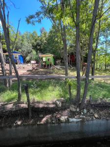 a view of a camping site with a lake and trees at Ancoa Lodge in Linares