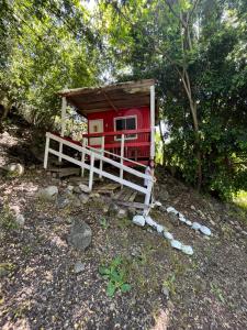 a red cabin with a person standing in front of it at Ancoa Lodge in Linares