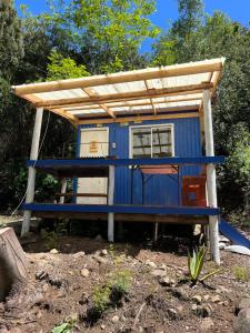 a blue house with a roof on top of it at Ancoa Lodge in Linares +14 photos