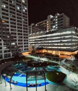 een groot zwembad voor een gebouw 's nachts bij Zhafira Retreat in Manilla