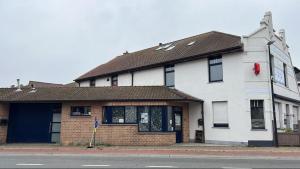 een wit gebouw met een rood item aan de zijkant bij Gastenkamer BLOOM in Brugge