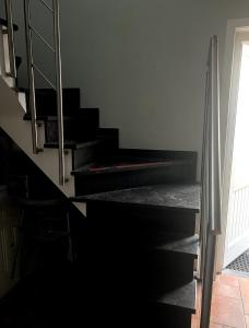 een trap met zwarte treden en een trapleuning bij Gastenkamer BLOOM in Brugge +2 foto's