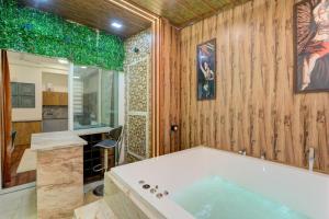 Un baño con bañera y paredes de madera. en Sunworld Arista, en Noida