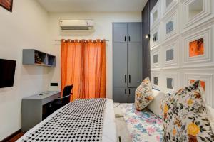 Un dormitorio con una cama y un escritorio y una ventana. en Sunworld Arista, en Noida
