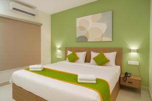 a bedroom with a large bed with green walls at Elegant Residency in Coimbatore