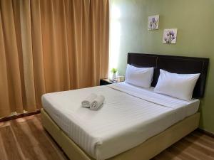 a bedroom with a bed with two towels on it at Five Ferns Hotel in Bandar Baru Bangi