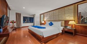 a bedroom with a large bed and a television at Sandals Stay Hotel in Da Nang