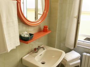 a bathroom with a sink and a mirror at Albergo Corona in Salsomaggiore Terme