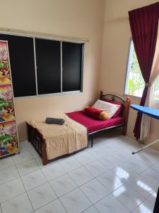 テメルローにあるAHA Homestay Temerloh with 3 bedrooms, 2 toiletのベッドと窓のある小さな寝室