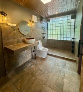 een badkamer met een toilet, een wastafel en een spiegel bij Montego Lakeview House with Taal View in Ulot