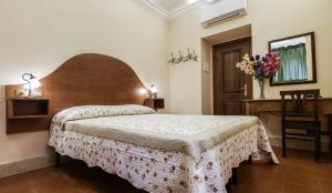 a bedroom with a bed and a desk with flowers on it at Hotel 4 Coronati in Rome