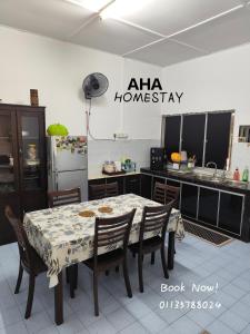 テメルローにあるAHA Homestay Temerloh with 3 bedrooms, 2 toiletのテーブルと椅子と冷蔵庫のあるキッチン +5枚の写真