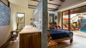 a bathroom with a bed and a sink in a room at Khwan Beach Resort - Luxury Glamping and Pool Villas Samui - Adults Only - SHA Extra Plus in Mae Nam