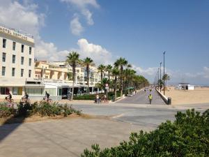 バレンシアにあるCasa Paulaの椰子の木が茂る通りと浜辺の建物