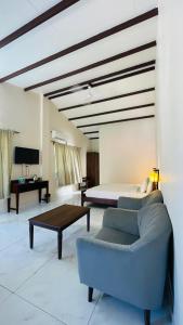 a bedroom with a bed and a couch and a table at Big Mama Corbett in Belparāo