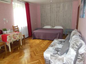 スラヴャンスク・ナ・クバニにあるMini-Hotel Svetlanaのベッド、ソファ、テーブルが備わる客室です。