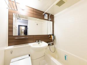 Un baño con lavabo, inodoro y espejo. en APA Hotel Kitakami Ekinishi, en Kitakami