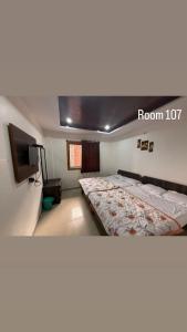 a bedroom with a bed with a room sign on it at Hotel Green Forest Mahableshwar in Mahabaleshwar