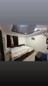 a bedroom with a bed with a room sign on it at Hotel Green Forest Mahableshwar in Mahabaleshwar +5 photos