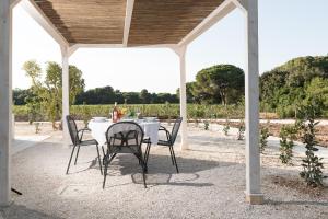 a white table and chairs under a pavilion with a view of a field at Masseria Mongiò dell'Elefante in Otranto