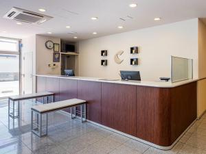 a hospital reception counter with two stools and a laptop at Comfort Hotel Tendo in Tendo