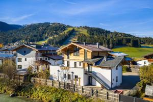 a group of houses on a hill next to a river at S Apartment in Flachau