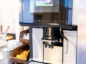 a coffee machine with a box of oranges at Comfort Hotel Tendo in Tendo