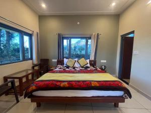 a bedroom with a large bed and two windows at 11 Gaon Homestay Lansdowne in Lansdowne