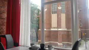 a window with a view of a brick building at hostelswidnicka24 in Wrocław