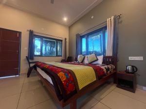 a bedroom with a bed and two windows at 11 Gaon Homestay Lansdowne in Lansdowne