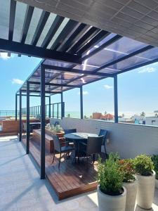 a deck with a table and chairs on a roof at Legacy 702 - vista para o mar in João Pessoa +27 photos