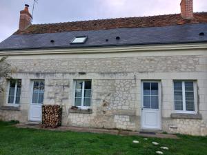 a stone house with white doors and a roof at Etape à Villeperdue in La Barillonnerie
