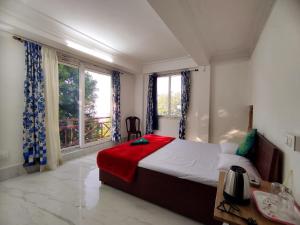 a bedroom with a bed and a large window at Marmen Homestay in Kalimpong