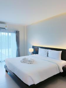 a bedroom with a large bed with white sheets at Phuketa - SHA Extra Plus in Phuket Town