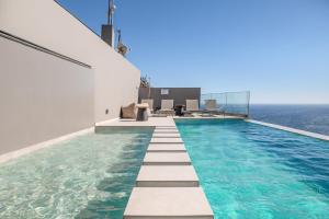an infinity pool with the ocean in the background at Dione Villa in Sellía +46 photos
