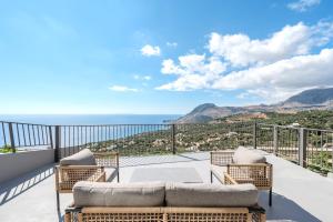 a balcony with wicker furniture and a view of the ocean at Dione Villa in Sellía