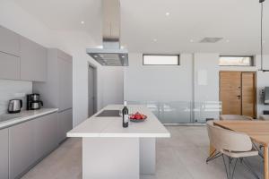 una cocina blanca con una mesa y un comedor en Dione Villa, en Sellía