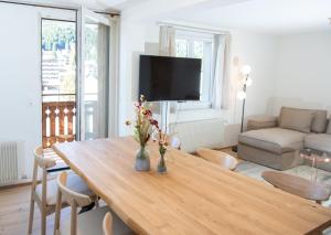 a living room with a wooden table with flowers on it at Apartment with mountain view in Lenzerheide