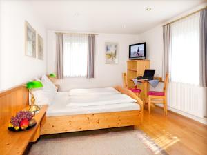 a bedroom with a bed and a desk with a laptop at Gasthof Rothmayr in Linz