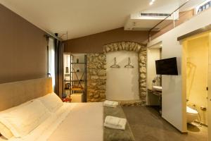 une chambre avec un grand lit et une télévision dans l'établissement 18Th Century Farmhouse In Racalmuto Countryside, à Grotte