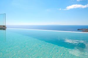 a swimming pool with the ocean in the background at Zeus Villa in Sellía