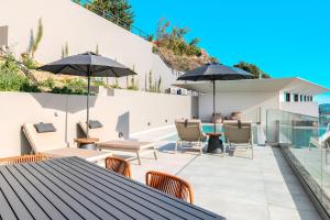 a patio with a table and chairs and umbrellas at Zeus Villa in Sellía +47 photos