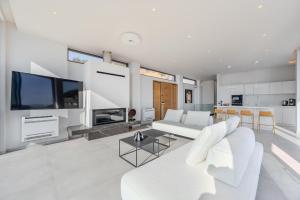 Una sala de estar con un sofá blanco y un televisor. en Zeus Villa, en Sellía