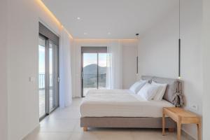 1 dormitorio blanco con 1 cama grande y ventanas grandes en Zeus Villa, en Sellía 47 fotos más